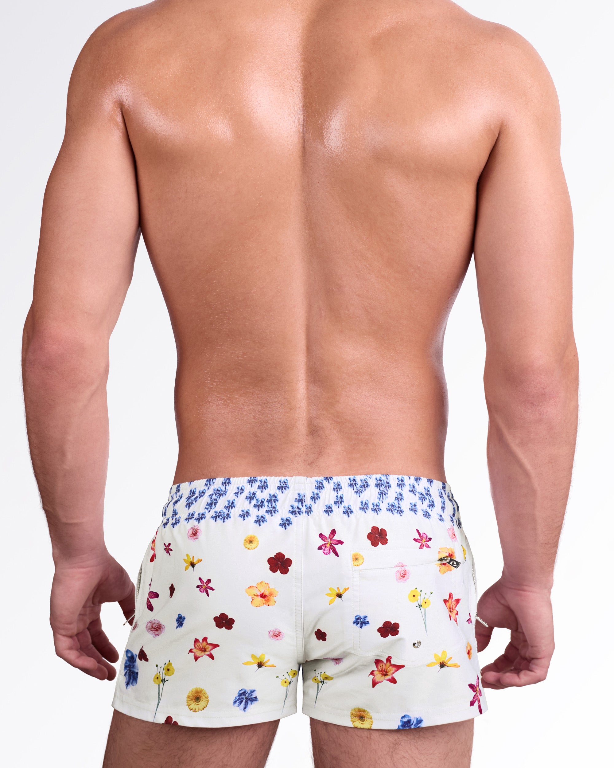 DC2 Flower Powers (Cream) Poolside Shorts — model wearing cream-colored poolside swim shorts featuring a vibrant scattered floral print, adjustable drawstring waistband, and modern short-length beach silhouette.
