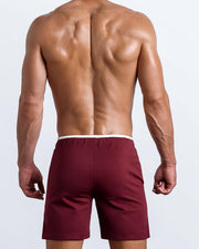 Back view of the men's above-knees length fitness workout shorts in a solid dark red color by BANG! menswear Miami.