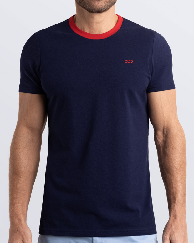 Frontal view of a male model wearing a navy blue Pima cotton t-shirt with a bold red collar, crafted for stylish casual wear and beachwear by DC2 Miami. Premium quality men&