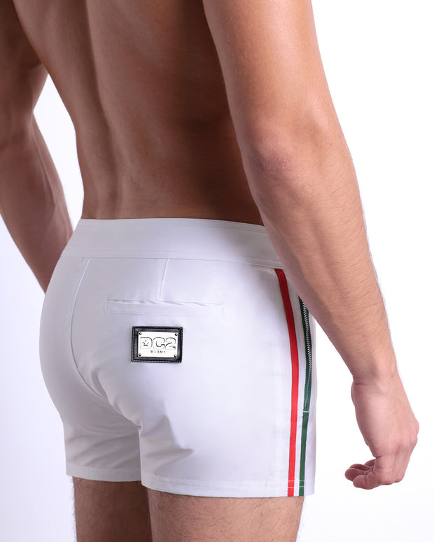 Side view of the FORZA WHITE men’s summer Beach Shorts, with dual zippered pockets. The shorts are in a solid white color with side green and red stripes for men made by DC2 a brand based in Miami.