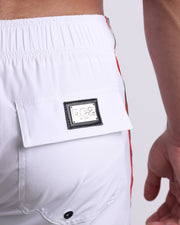 Close-up view of the FORZA WHITE men’s Flex Shorts back pocket, showing custom branded silver metal logo.