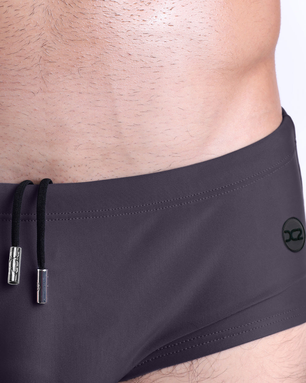 Close-up view of the GOTAHM GREY men’s drawstring briefs showing white cord with custom branded metallic silver cord ends, and matching custom eyelet trims in silver.
