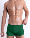DC2 GREEN RUSH — model wearing GREEN RUSH Swim Shorts, featuring a sleek retro-inspired square cut with a body-defining low-rise fit.