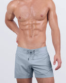 A male model wearing the GREY ANATOMY - Flex Shorts by DC2 Miami. These sleek, premium shorts come in a sophisticated grey tone with a structured flat-front waistband and lace-up fastening for a tailored look.