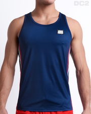Male model wearing IMPERIAL BLUE men’s casual Tank Top. A premium quality top in a solid navy color with red and white stripes on the sides, a men’s beachwear brand from Miami.
