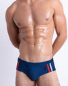 DC2 IMPERIAL BLUE — model wearing Imperial Blue Swim Briefs, featuring signature red, white, and navy stripes and a sleek low-rise silhouette.