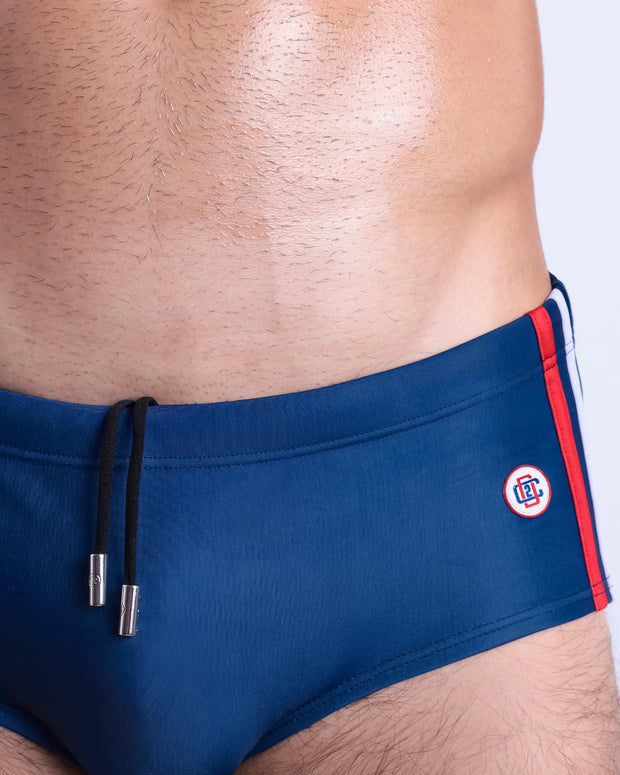 Close-up view of the IMPERIAL BLUE men’s drawstring briefs showing white cord with custom branded metallic silver cord ends, and matching custom eyelet trims in silver.