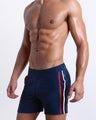 Model wearing the Imperial Blue Tailored Shorts with red and white side stripes, adjustable side buckles, and a polished fitted cut.
