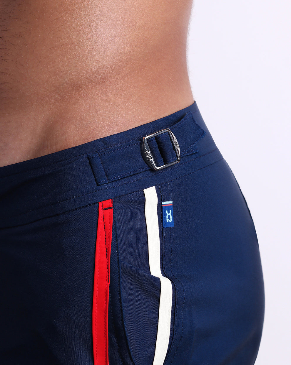 Close-up of the Imperial Blue Tailored Shorts highlighting the metal side buckle, red and white stripe trim, and side pocket detail.