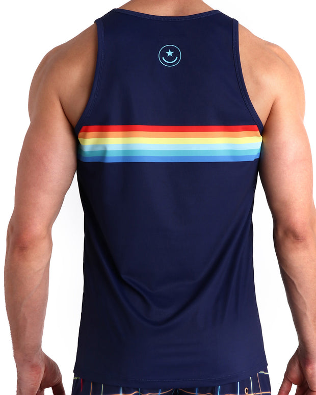 Back view of male model wearing the INFINITY STRIPES summer tank top for men by BANG! Miami in navy blue color featuring multi color red, orange, yellow and blue stripes inspired by by iconic P.L. Rolando&
