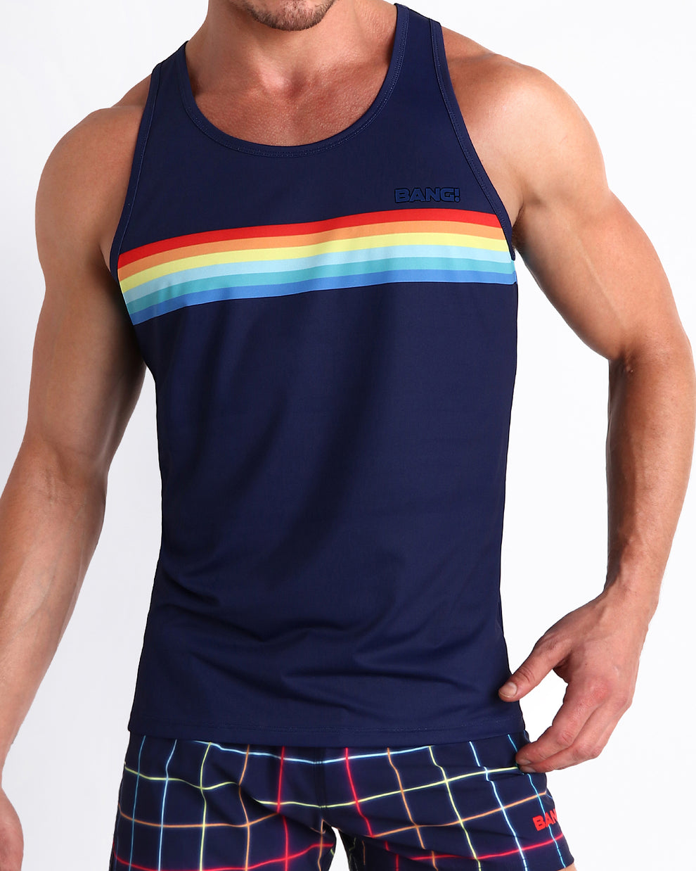 Front view of model wearing the INFINITY STRIPES men’s beach tank top in a navy dark blue color with rainbow stripes by the Bang! Clothes brand of men's beachwear from Miami.