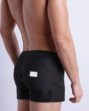 Side view of the JET BLACK Summer Beach Shorts with dual zippered pockets for men featuring a solid black color is designed by BANG! Clothes in Miami.