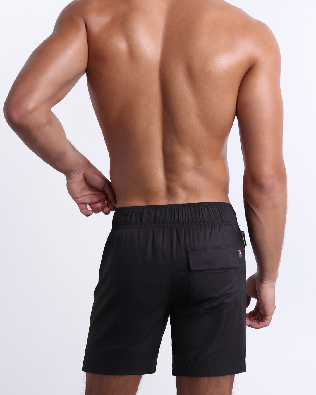 Back view of the Jet Black Flex Boardshorts showing the elasticized back waistband and flap-covered rear pocket.