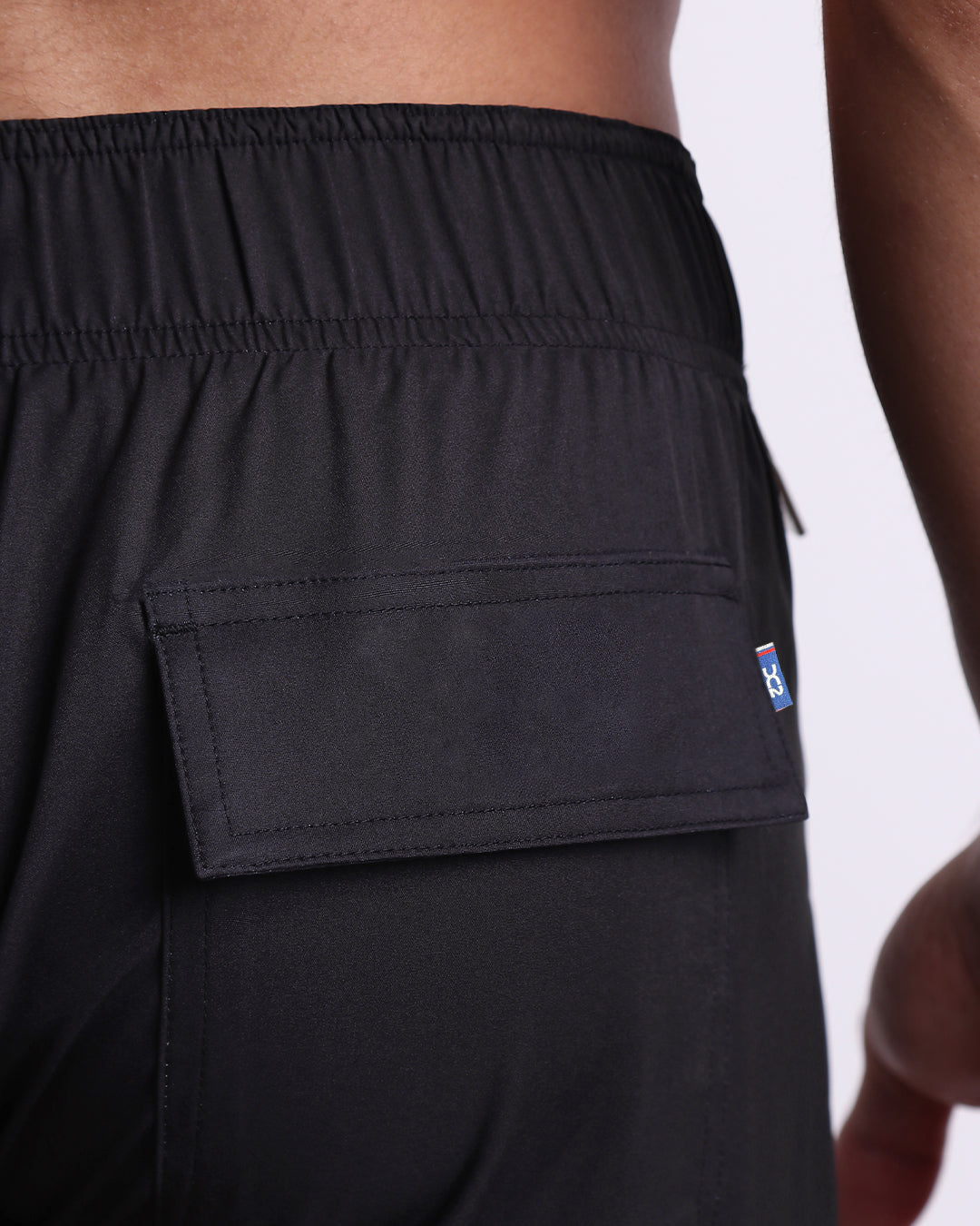 Close-up of the Jet Black Flex Boardshorts rear flap pocket with tonal stitching and a small DC2 logo tab.