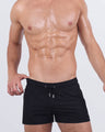 Model wearing JET BLACK Poolside Shorts featuring a sleek solid black design with drawstring waistband. A refined, athletic fit built for comfort and performance poolside.
