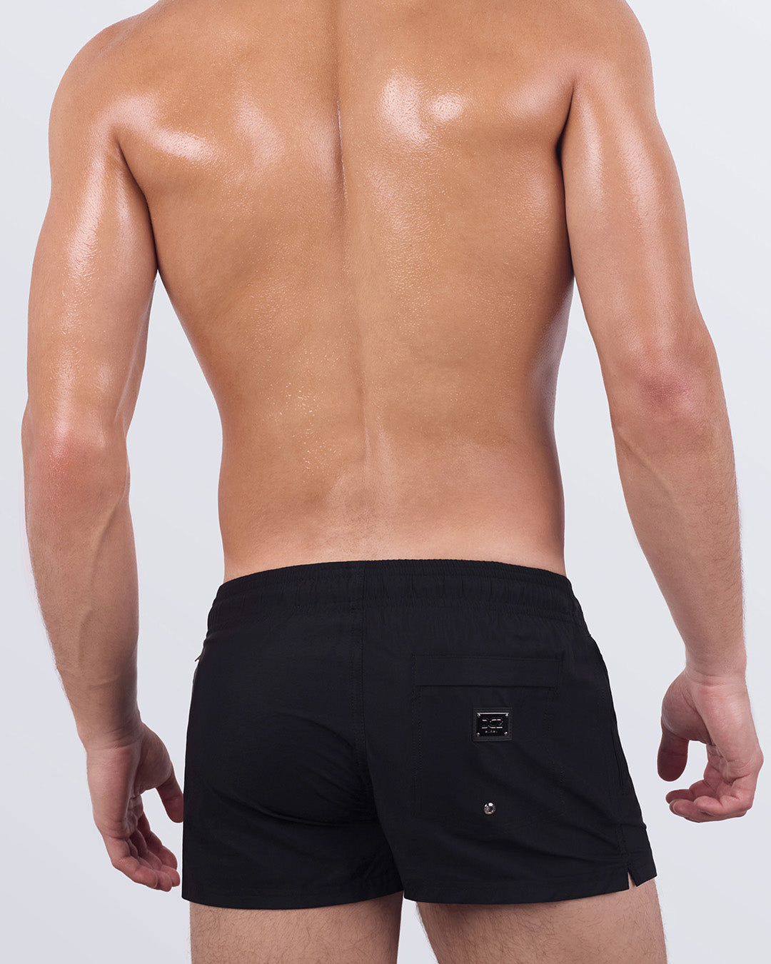 Back view of JET BLACK Poolside Shorts showing clean, minimal lines with rear patch pocket and branded logo. Designed with stretch comfort and modern structure.