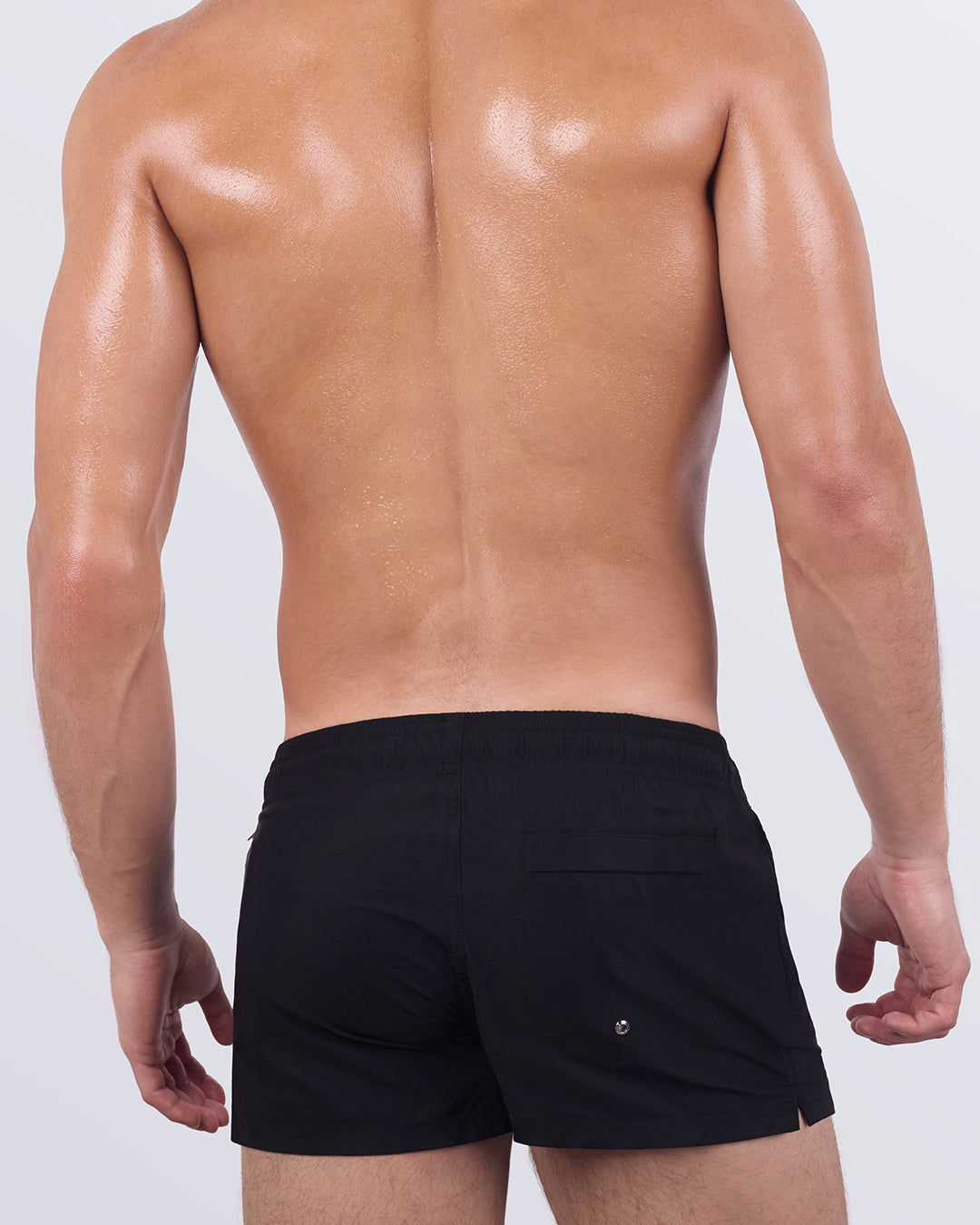 Back view of JET BLACK Poolside Shorts showing clean, minimal lines with rear patch pocket and branded logo. Designed with stretch comfort and modern structure.