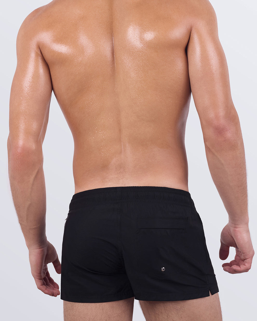 Back view of JET BLACK Poolside Shorts showing clean, minimal lines with rear patch pocket and branded logo. Designed with stretch comfort and modern structure.