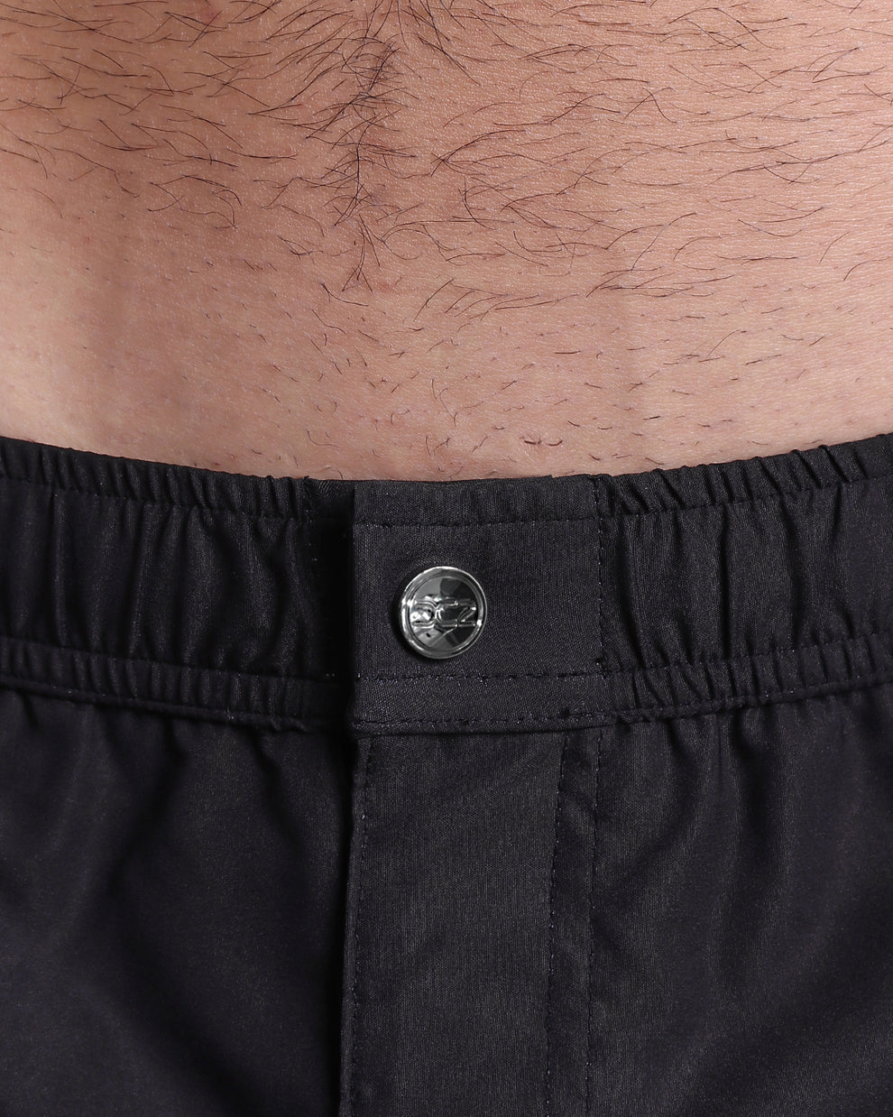 Close-up of the Jet Black Mini Shorts showcasing the elastic waistband, branded metallic snap, and concealed front closure.