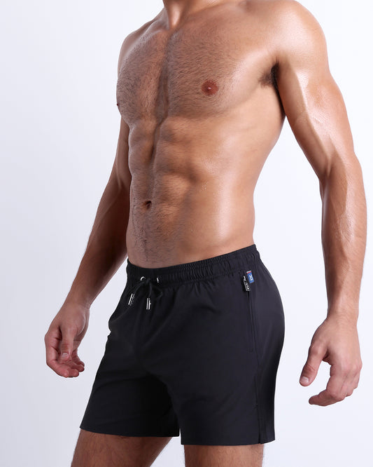 Model wearing the Jet Black Resort Shorts with a relaxed above-the-knee fit, elastic drawstring waistband, and water-repellent stretch fabric.