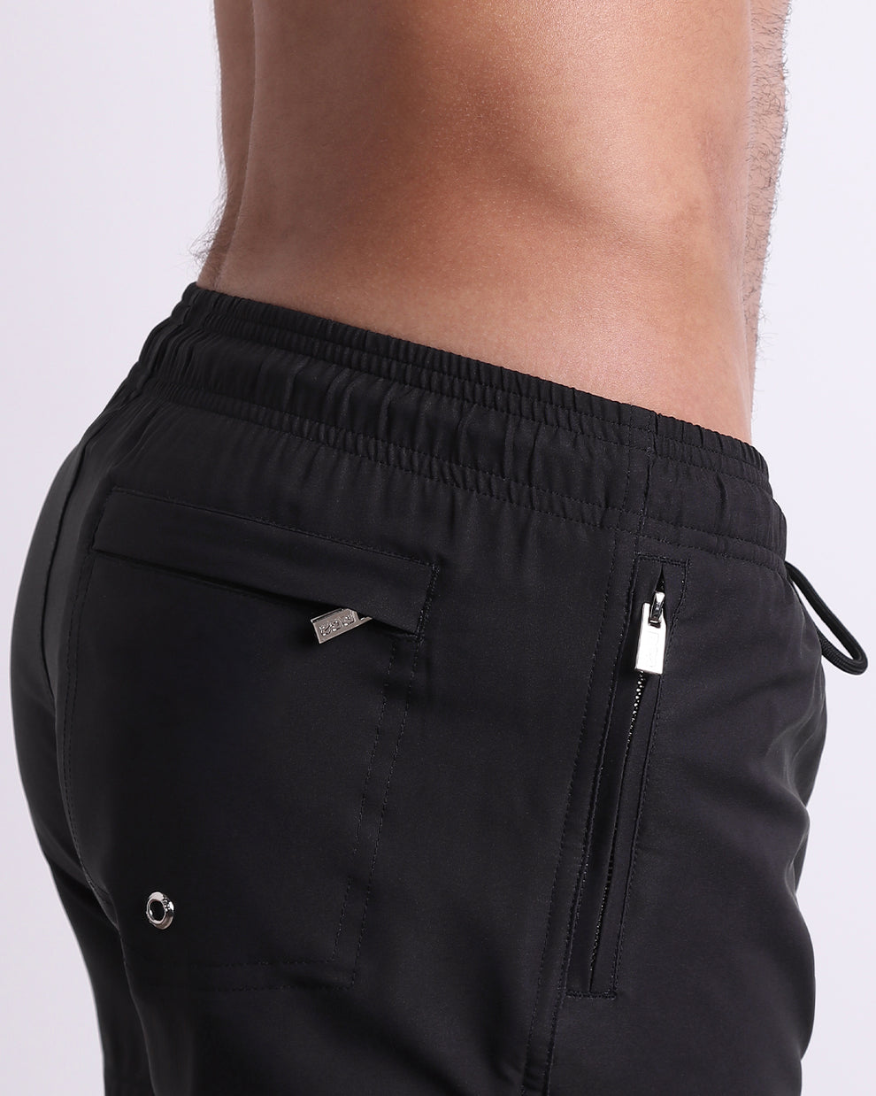 Close-up of the Jet Black Resort Shorts highlighting the fully-closing zip pocket, flap back pocket, and premium water-resistant fabric.