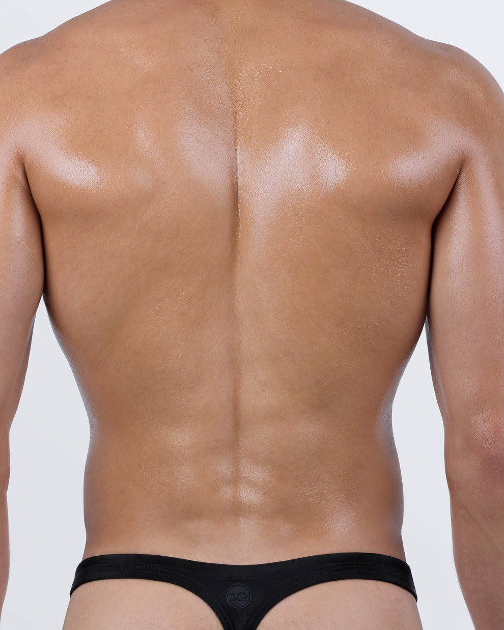 Back view of DC2 JET BLACK men's thong swimwear – classic T-back design ideal for tanning with sculpted fit and sleek micro coverage.
