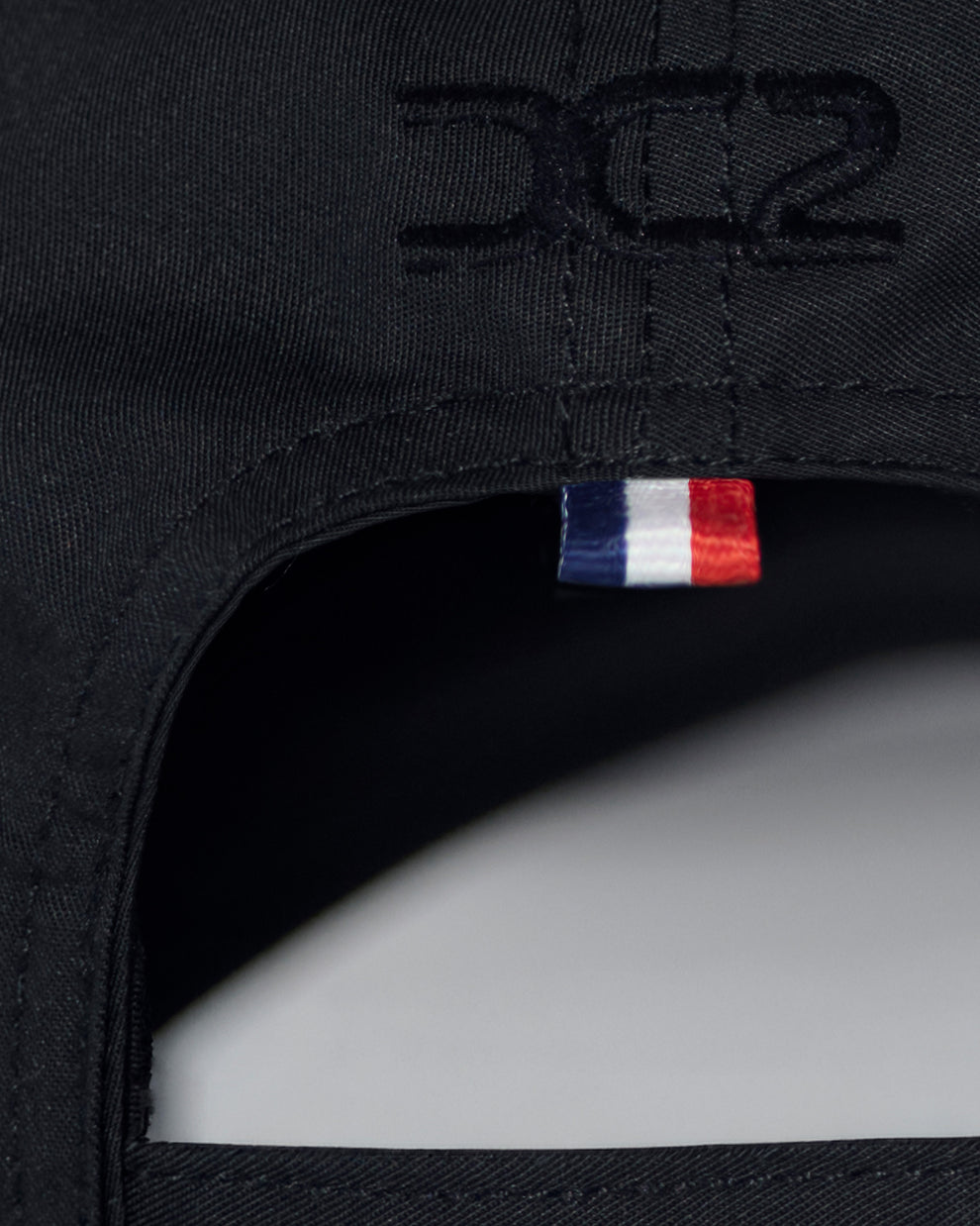 Interior detail of DC2 White Resort Cap — soft cotton lining, adjustable strap, and branded care label.
