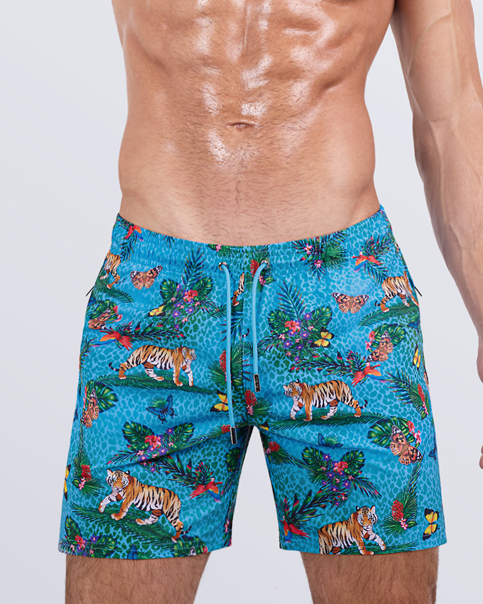 Close-up side view of a male model in the JUNGLE BOOGIE Resort Shorts for men by DC2 Miami. These striking swim shorts feature premium four-way stretch fabric, metallic zip pockets for secure storage, and water-resistant properties, making them perfect for both active beach days and casual summer outings.