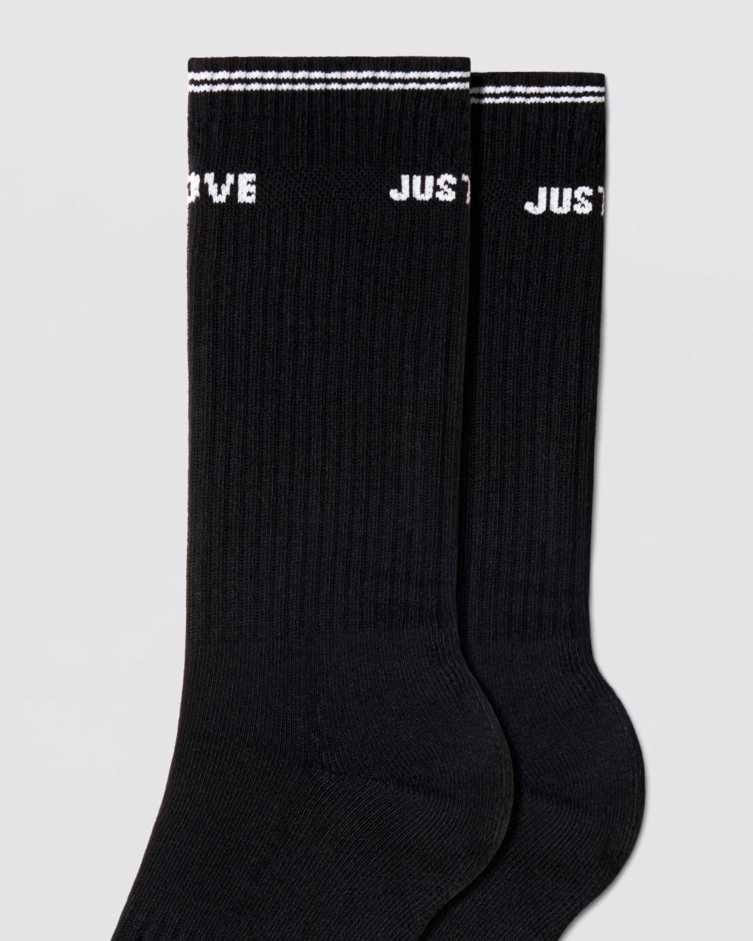 DC2 Justify My Love Ribbed Crew Socks (Black) — close-up of ribbed knit, white cuff stripe, and bold text detail.