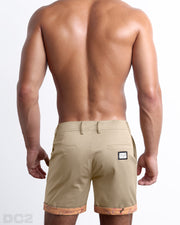 Back view of a model wearing woven twill cotton chino shorts in a light tan color for men. These premium quality swimwear bottoms are DC2 by BANG! Clothes, a men’s beachwear brand from Miami.