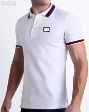 Male model wearing a slim-fitting, LOTUS WHITE Pima Cotton Polo Shirt by Miami-based DC2. Solid white with red and navy blue stripes on ribbed-knit collar and cuffs.