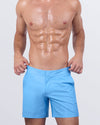 A male model wearing the Magnet Blue Tailored Shorts from DC2 Miami. The shorts feature a sleek, tailored fit in a vibrant blue hue with adjustable side buckles.