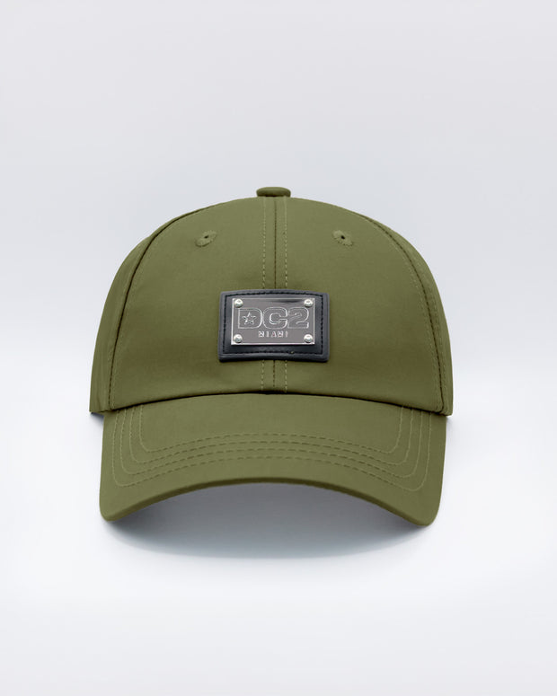 Close-up of a MAGNUM GREEN Baseball Cap with polished DC2 metallic silver plaque.