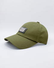 Close-up of a MAGNUM GREEN Baseball Cap with polished DC2 metallic silver plaque.