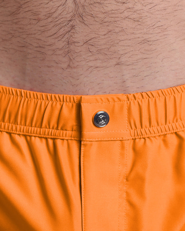 Close-up view of the men’s summer mini shorts, showing custom branded metal button in metallic silver.