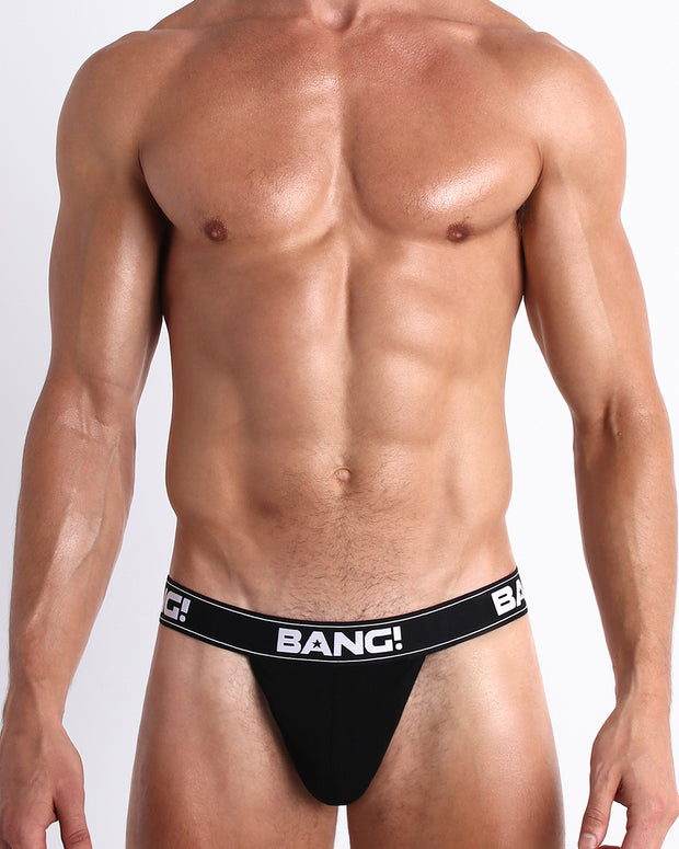 Front view of a sexy male model wearing a BANG! Cotton Thongs for men in the MAX BLACK offering BANG!’s signature low-rise fit sits sexier than traditional men’s underwear.