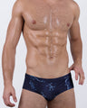 Front angled view of BANG! Mermen Masters Swim Brief – black swimwear featuring mythical mermen illustrations inspired by classical art, with a sleek low-rise fit.
