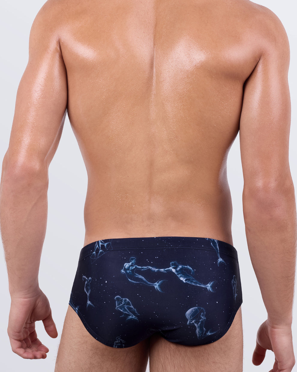 Back view of Mermen Masters Swim Sunga by BANG! – featuring artistic merman illustrations across a galaxy-like navy background with sculpted fit.