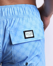 Close-up view of the MONO BLUE men’s Flex Shorts back pocket, showing custom branded silver metal logo.