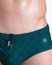 Close-up view of the MONO TEAL men’s drawstring briefs showing black cord with custom branded metallic silver cord ends, and matching custom eyelet trims in silver.