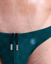 Close-up view of the MONO TEAL men’s drawstring briefs showing black cord with custom branded metallic silver cord ends, and custom DC2 logo.