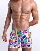 Male model wearing MOSAIC beach Flex Shorts, premium swimwear with a stylish multi-color mosaic shape design for men. These high-quality swimwear bottoms by BANG! Clothes, a men’s beachwear brand from Miami.