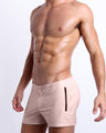 Side view of the NAKED PINK Summer Beach Shorts with dual zippered pockets for men featuring a light rose gold color is designed by BANG! Clothes in Miami.