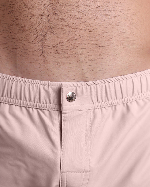 Close-up view of the NAKED PINK men’s Mini shorts, showing custom branded metal button in gold by Bang!