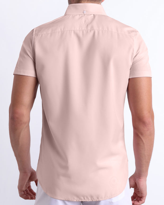 Back view of a male model wearing a NAKED PINK men’s Hawaiian shirt featuring a light rose gold color by the Bang! Clothes brand of men&