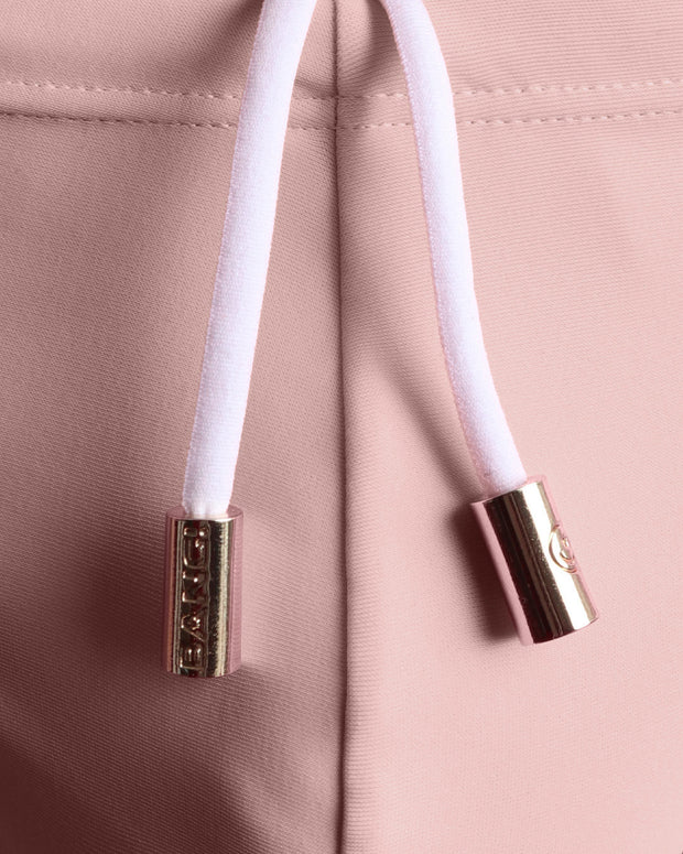 Close-up view of the NAKED PINK men’s drawstring briefs showing white cord with custom branded golden cord ends, and matching custom eyelet trims in gold.
