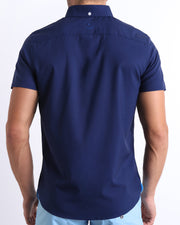 Back view of a male model wearing a NAVY BOOMER men’s Hawaiian shirt featuring a navy blue color by the Bang! Clothes brand of men's beachwear.