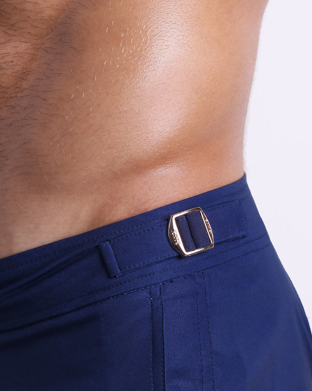 Close-up view of the NAVY BOOMER men’s swimwear, showing custom branded golden adjustable side buckles.