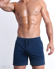 Frontal view of male model wearing the NAVY 2-in-1 Endurance Shorts in a solid navy blue quick-dry by DC2 brand of men's beachwear from Miami.