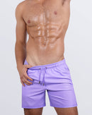 Frontal view of sexy model wearing the NEO VIOLET men’s all-purpose swimwear bottoms in a neon purple color by the DC2 brand of men's beachwear from Miami.
